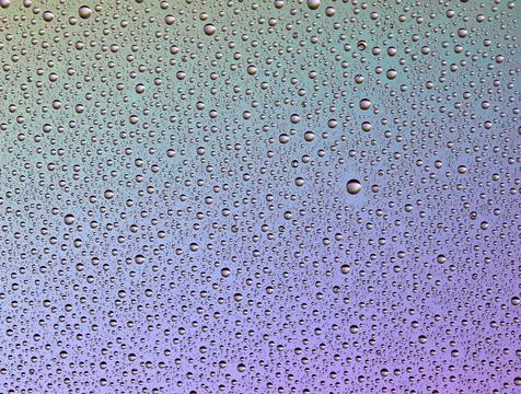 Drops on glass of different sizes and colors on a colored background, texture Stock Photos