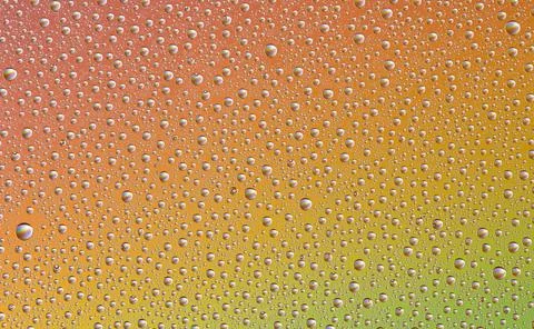 Drops on glass of different sizes and colors on a colored background, texture Stock Photos