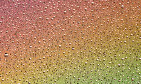 Drops on glass of different sizes and colors on a colored background, texture Stock Photos