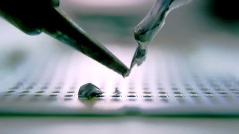 Drops of melted silver metal fall down on device panel Stock Footage 246666749