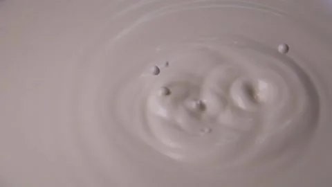 Drops of milk fall from above in super slow motion Stock Footage 230896943