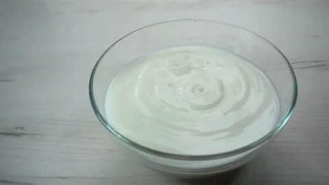 Drops of milk fall in slow motion into a bowl filled with milk Stock Footage 131114583
