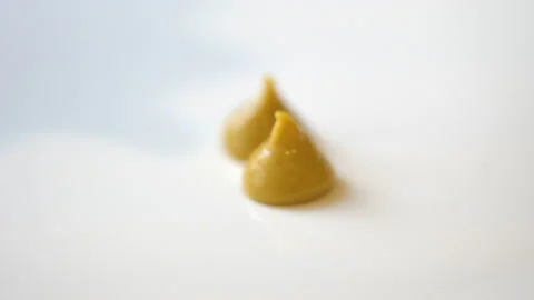 Drops of mustard fall on a white background 4K Stock Footage 128153694