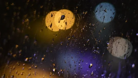 Drops of night rain on dirty window with bokeh lights background Video stock 143570215
