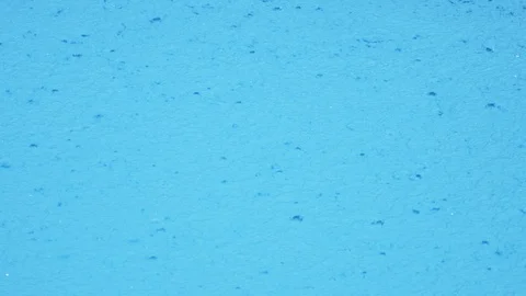 Drops of pouring rain fall into the blue water of the pool. close-up. 4k, slow Vidéo 94908431
