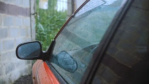 Drops of rain beat on the side window of the car. Stock Footage 77174905