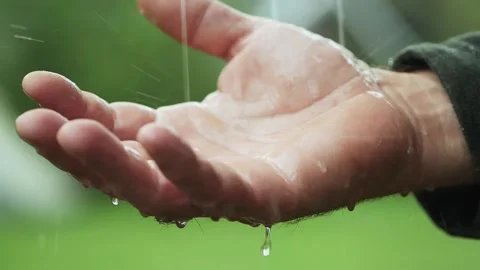 Drops of rain dripping into man hand Stock Footage 136116089