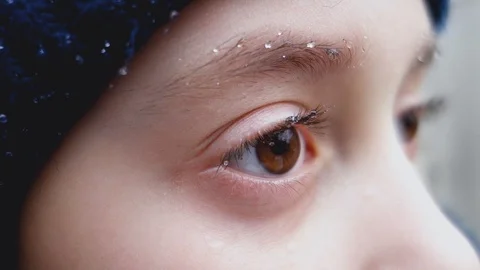 Drops from the rain on the eyelashes and eyebrows of a little girl. Video stock 104662656