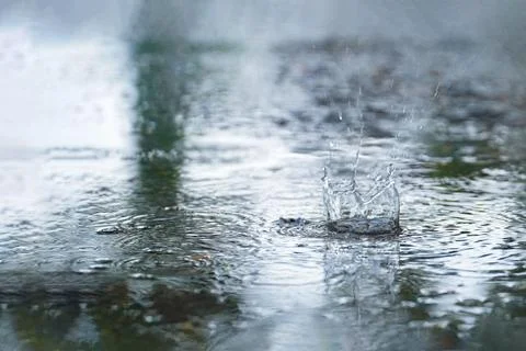 Drops of rain that fall on the asphalt when it rains. close-up rain drops. .. Stock Photos