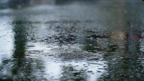 Drops of rain that fall on the asphalt when it rains. close-up rain drops. .. Stock Photos