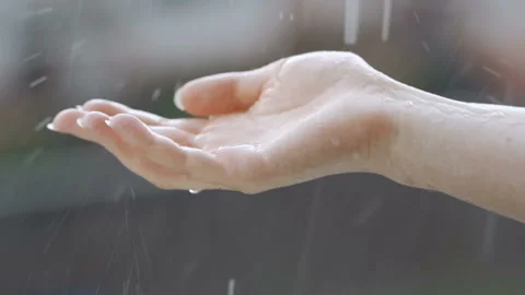 Drops of rain fall into the hands of a young woman Stock Footage 92622466