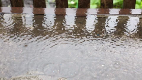 Drops of rain fall in a puddle. Stock Footage 133822642