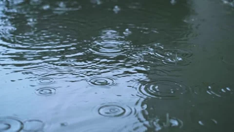 Drops of rain fall into a puddle, heavy street rain, advertising tires that prov Stock Footage 277643057