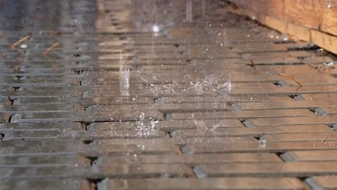 Drops of rain fall in a puddle. video close-up of the rain on the footpath. life Stock Footage 93468572
