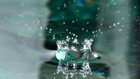 Drops of rain fall into the water, selective focus close-up Stock Photos