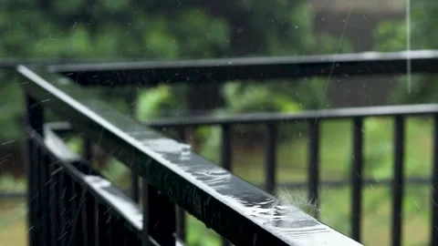 Drops of rain falling and splasing onto the fence of the balcony. Stock Footage 245908312