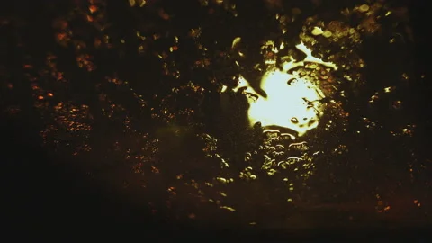 Drops of rain flow down the glass against the bokeh background of moving cars Stock Footage 107651060