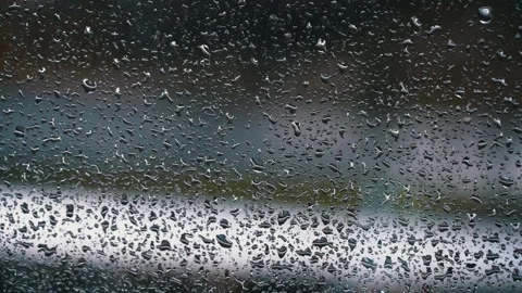 Drops of Rain Flow Down the Glass Against the Backdrop of Moving Cars Stock Footage 256163735