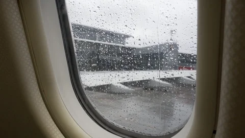 Drops of rain flow down the window glass. The plane takes off in bad weather Vídeos de archivo 117753232