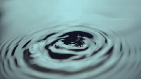 Drops of rain form bubbles and light waves on water surface Stock Footage 234423086