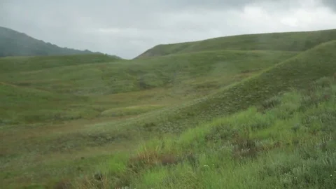 Drops of rain on the glass against the background of green hills Stock Footage 79340166