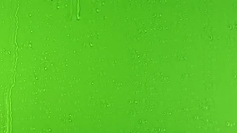 Drops of Rain trickling down on green background Stock Footage 138540863