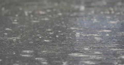 Drops of rain water fall down onto paved road. Stock Footage 284428230