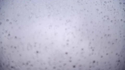 Drops of rain water falling through a window in 4k Stock-Footage 130183440