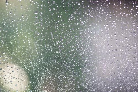 Drops of rain on window with abstract lights Stock Photos