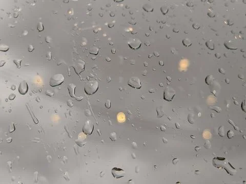 Drops of rain on window with abstract lights. Stock Photos