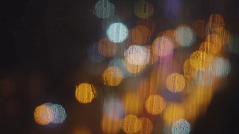 Drops of rain on the window and glare of light from passing cars 库存影片 76617768