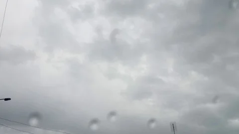 Drops of rain on a window with a gray sky behind Stock Footage 91707977