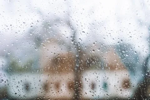 Drops of rain on a window pane, Blur house in background. Stock Photos