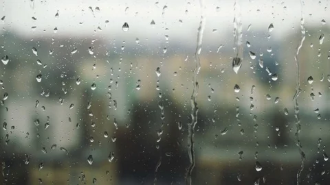 Drops of rain on a window pane, buildings in background Stock Footage 83431125