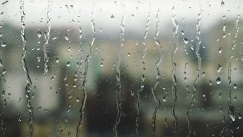 Drops of rain on a window pane, buildings in background Video stock 83552999