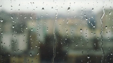 Drops of rain on a window pane, buildings in background Stock Footage 83578575