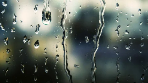 Drops of rain on a window pane, buildings in background Stock Footage 83579121