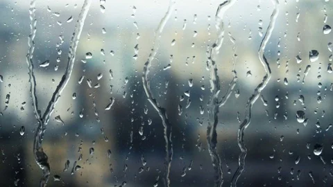 Drops of rain on a window pane, buildings in background Stock Footage 83610762