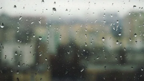 Drops of rain on a window pane, buildings in background Stock Footage 83610818