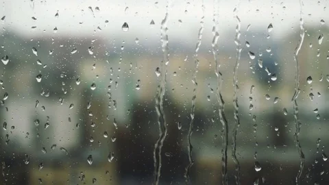 Drops of rain on a window pane, buildings in background Stock Footage 83610903