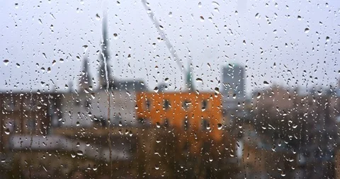 Drops of rain on a window pane, buildings in background Stock Footage 104872236