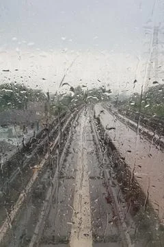 Drops of rain on a windows of a subway with train track as background Stock Photos