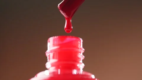 Drops of red nail polish falling from a brush, macro. Varnish nail polish. Stock Footage 305513019