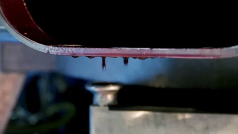 Drops of red wine flow from the open stainless steel tank, close up Stock Footage 99104601