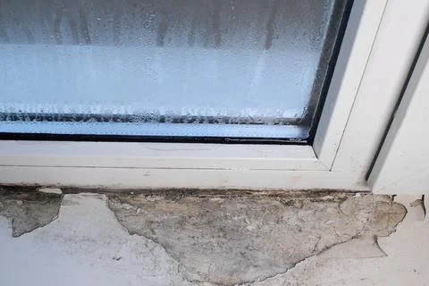 Drops run down the glass of the window. due to moisture, the window sill co.. Stock Photos