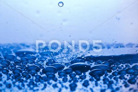 Drops, sprays, splashes of water on a colorful background Stock Photos