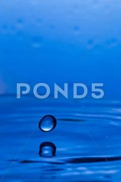 Drops, sprays, splashes of water on a colorful background Stock Photos