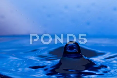 Drops, sprays, splashes of water on a colorful background Stock Photos