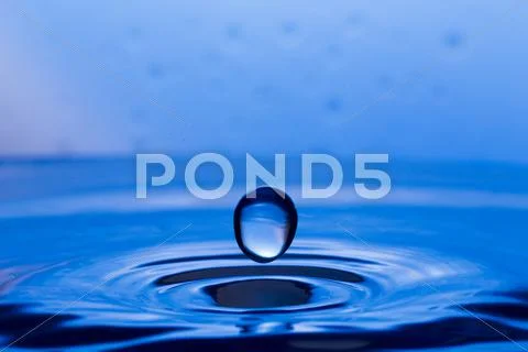 Drops, sprays, splashes of water on a colorful background Stock Photos