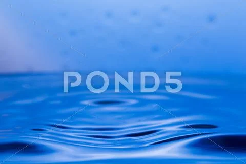 Drops, sprays, splashes of water on a colorful background Stock Photos